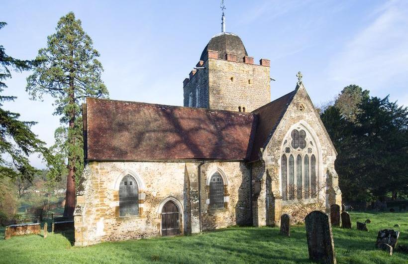 Sunlit image of the exterior of St Peter and St Paul's Church, Albury, Surrey